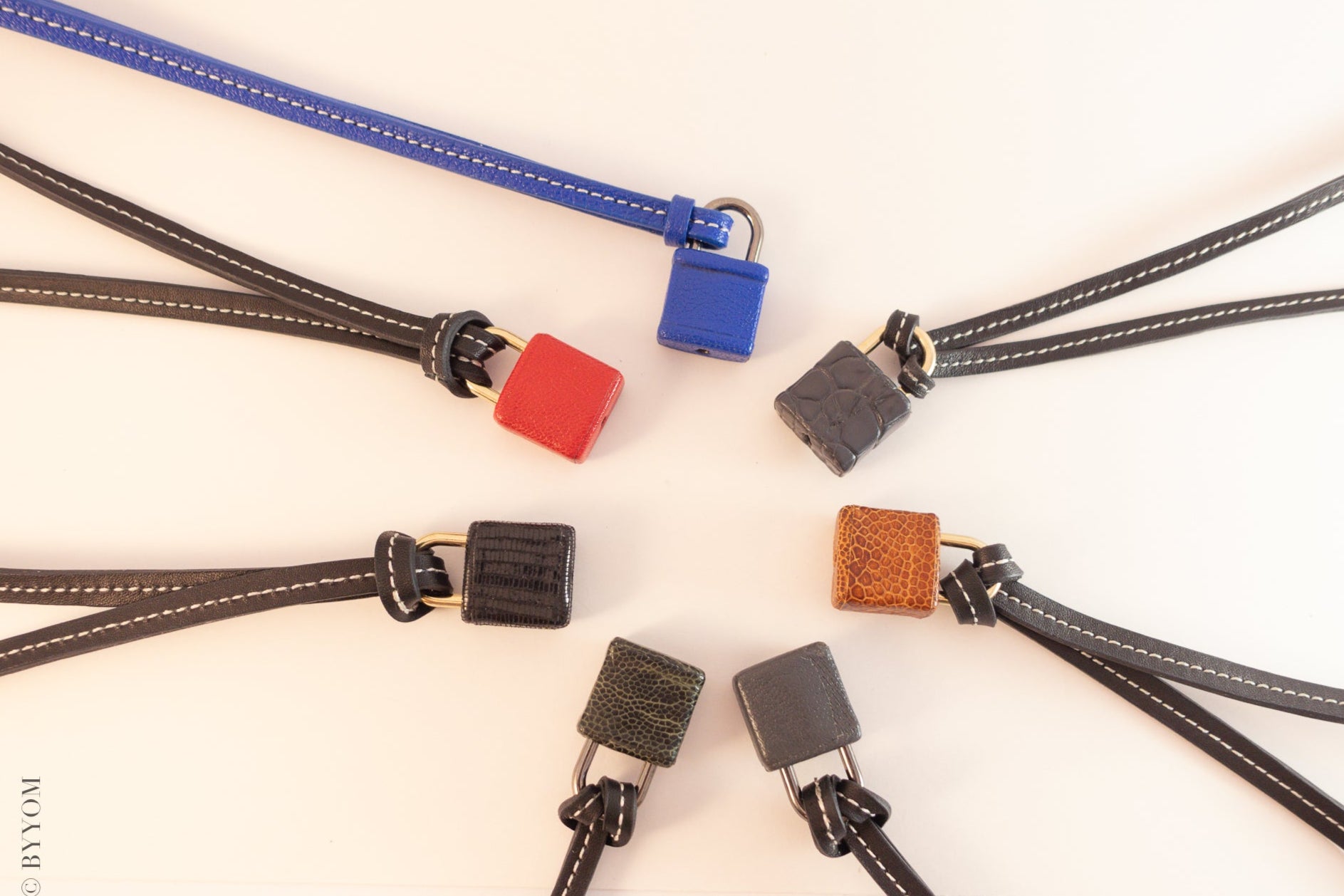 Collection of colorful leather covered locks with leather lanyards in white background