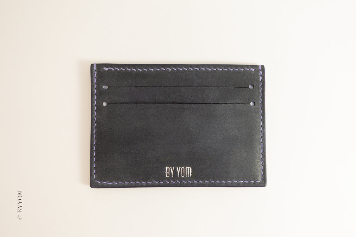 Navy Nubuck leather cardholder with 'BY YOM' branding on a beige background